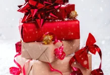 What’s a Good Secret Santa Gift for a Coworker You Don’t Know Well? Stack of wrapped Christmas gifts with red bows
