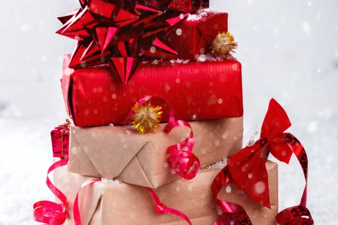 Stack of wrapped Christmas gifts with red bows