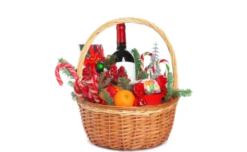 55 Best Christmas Food Gifts Christmas gift basket filled with wine, candy canes, oranges and sweets