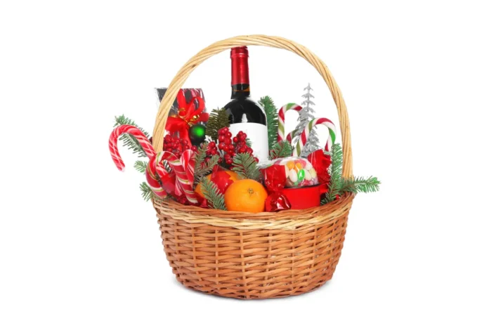Christmas gift basket filled with wine, candy canes, oranges and sweets