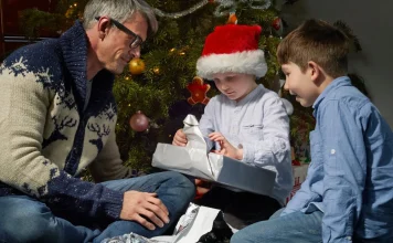 Dad and sons opening Christmas presents together