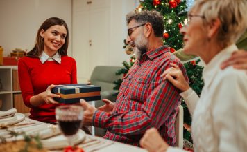 What Should You Bring Your Boyfriend’s Parents the First Time You Meet Them at Christmas? Young woman handing a Christmas gift to an older couple