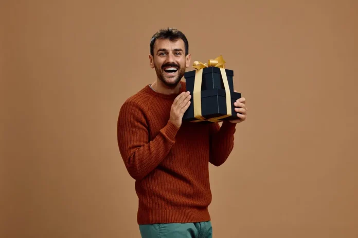Smiling man holding a stack of gift boxes