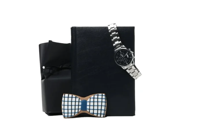 Luxury gift set for men with a wristwatch and wooden bow tie on a black gift box