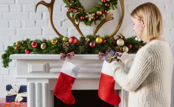 34 Best Stocking Stuffers for Women (Mostly Under $40) Woman putting a gift in a Christmas stocking
